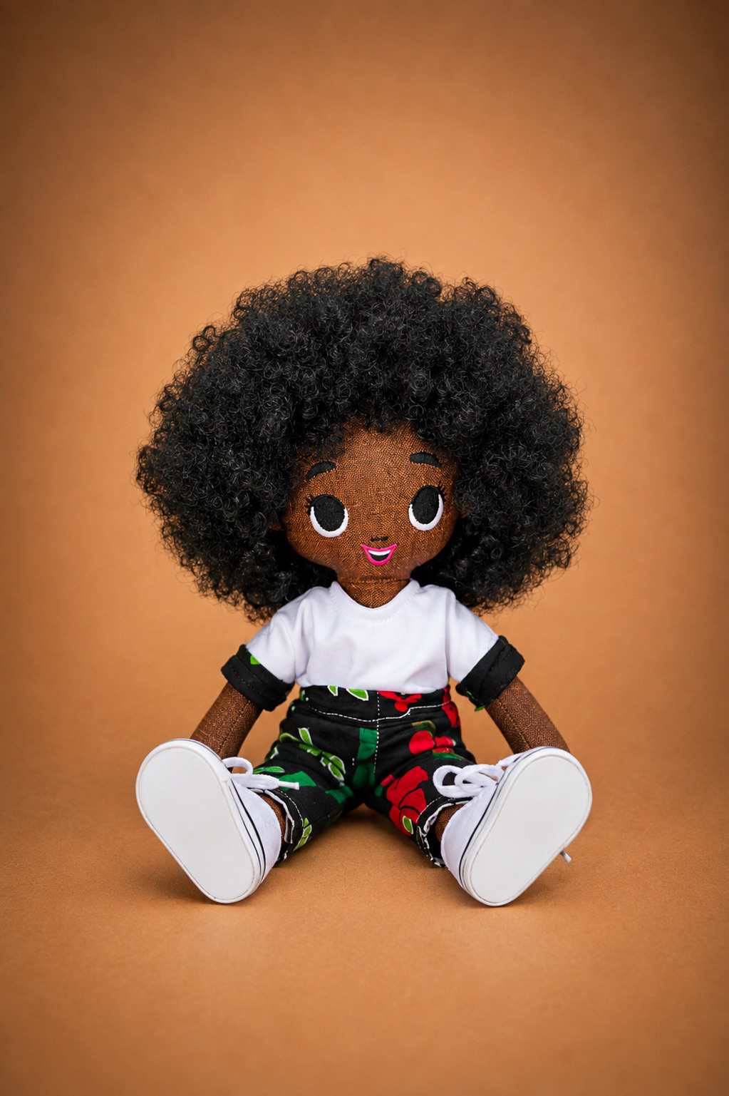 Seated Tara doll wearing a black floral outfit